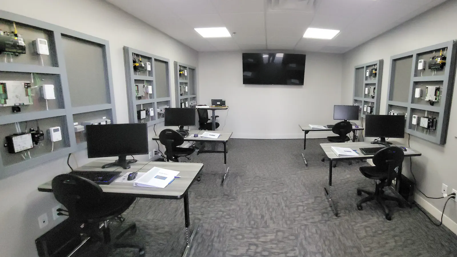 WebCTRL training classroom with student workstations and wall-mounted controller training boards